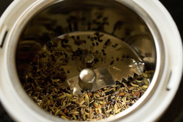 achari paneer masala spices in a grinder prior to blending