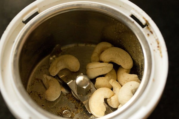 cashews for achari paneer recipe that have been added to a spice grinder