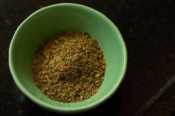 achari spices that have been placed in a small green bowl