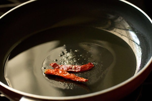 ghee in a pan with some dried red chiles