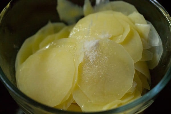 Tossing blanched potatoes with salt and oil.