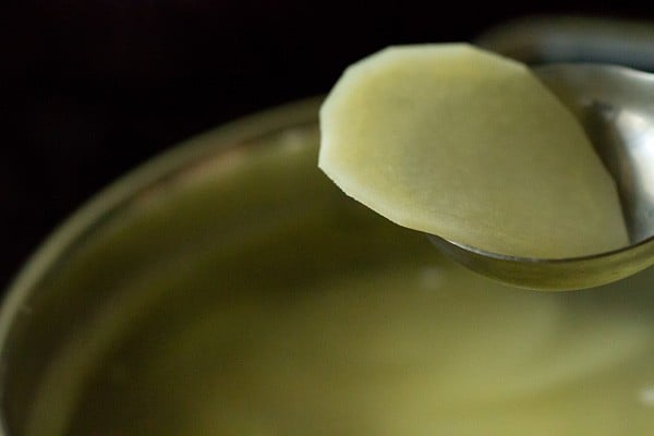 showing the potatoes are translucent after blanching step for homemade potato chips recipe.