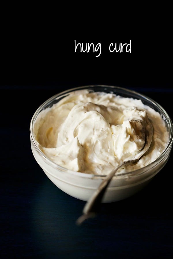 hung curd or greek yogurt served in a bowl with a spoon in it and text layover.