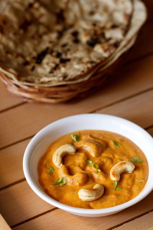 kaju masala served in a white bowl with tandoori roti