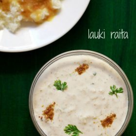 lauki ka raita in a glass bowl sprinkled with roasted cumin powder and coriander leaves on a dark green board