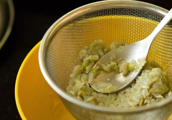 lauki being pressed with a spoon in the strainer