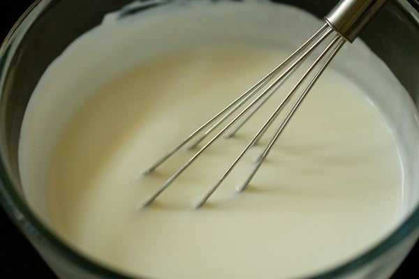 curd being whished for lauki raita recipe