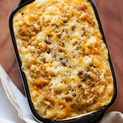 mac and cheese served in a black rimmed baking dish.