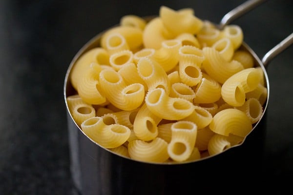 dry elbow macaroni in a measuring cup.