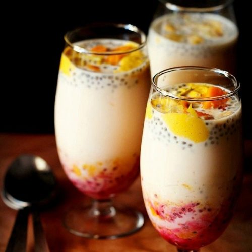 mango falooda served in three glasses with spoons kept on the side.