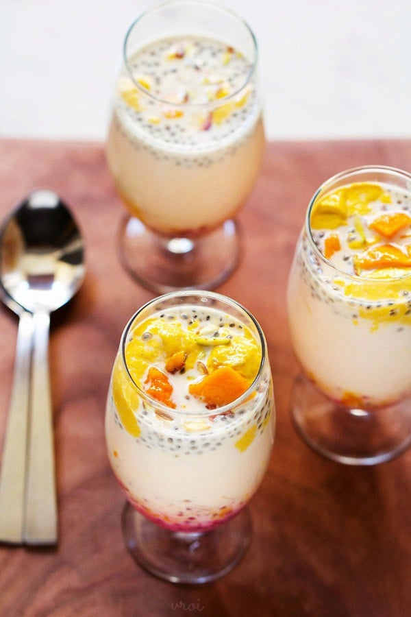 mango falooda served in three glasses with spoons kept on the side. 