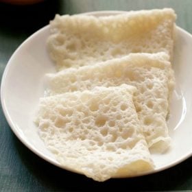 three folded neer dosas on a white plate