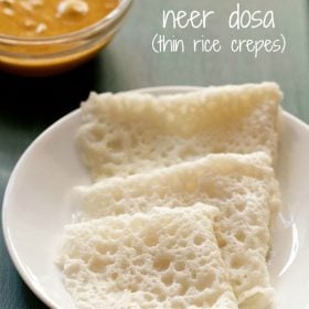 three folded neer dosas on a white plate with a bowl of veg kurma in the background