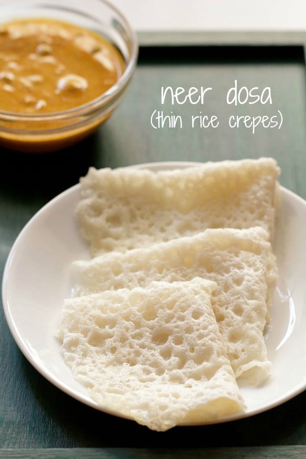 three folded neer dosas on a white plate with a bowl of veg kurma in the background