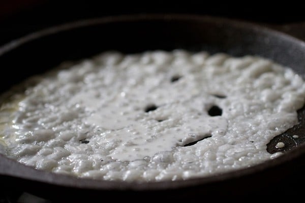 preparing neer dosas by filling in large gaps with more batter