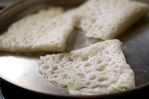 three neer dosas cooling on a plate without touching