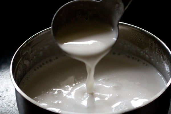 spoon drizzling neer dose batter to show proper consistency