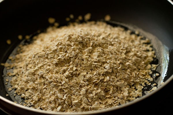 roasting oats in saucepan for oats upma recipe