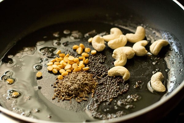 oats, lentils, cumin seeds and cashews added to saucepan