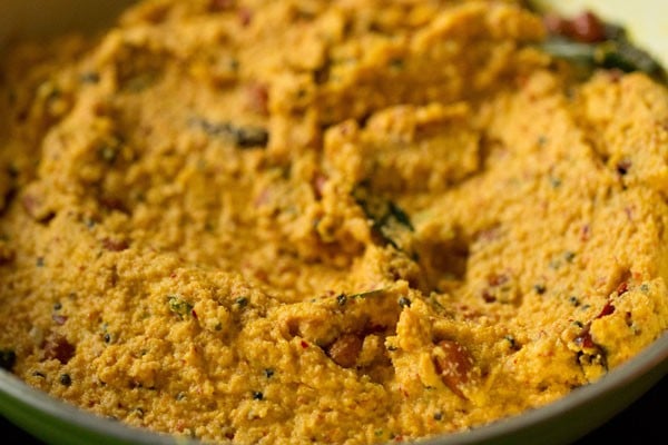 sautéing raw mango-coconut-spices paste in the pan. 