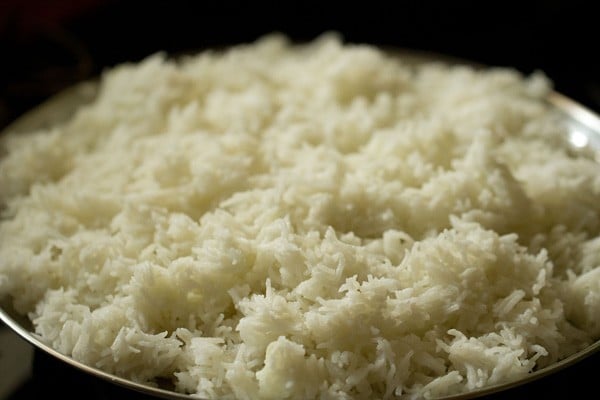 cooked rice spread on a plate for cooling. 