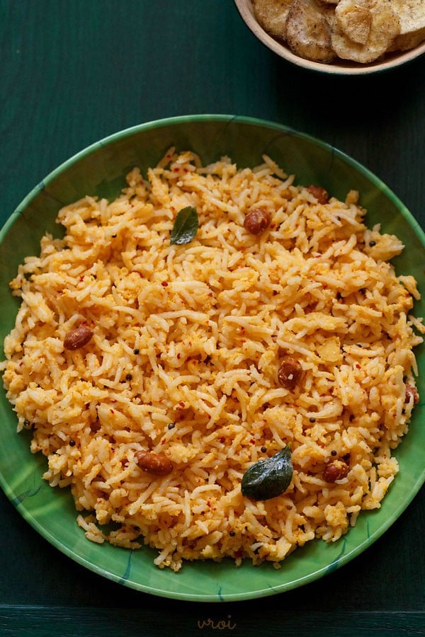 mango rice served in a bowl with banana chips. 