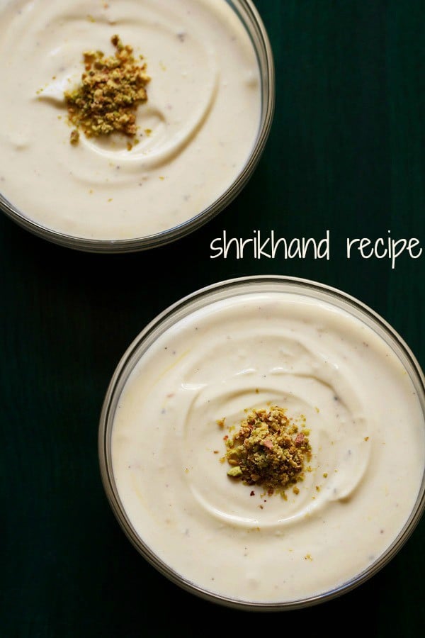 top shot of shrikhand with chopped pistachios on a dark green serving tray with a text layover