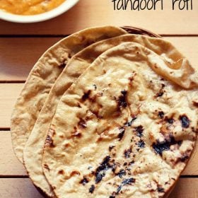 three tandoori roti placed on top of a rattan roti box on a cream colored wooden board