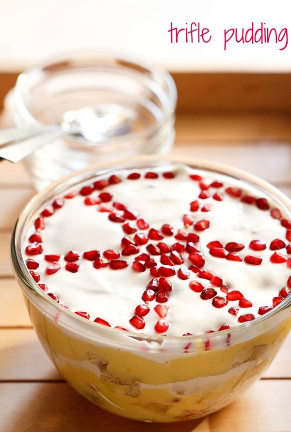 top shot of trifle with top cream layer garnished with wheel like design with pomegranate seeds.