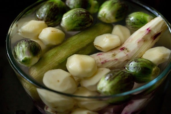 other vegetables placed in a bowl of water for undhiyu recipe.