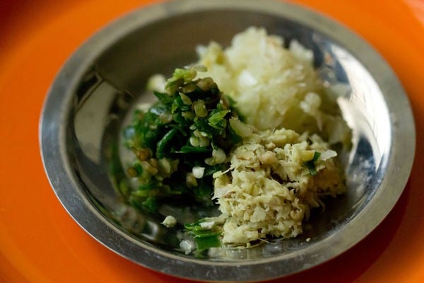 ginger, garlic cloves and green chilies crushed in mortar pestle for undhiyu recipe.