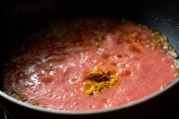 tomato puree, turmeric and red chili powder in kadai pan