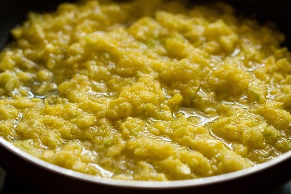 cooking the raw mango mixture in the pan. 