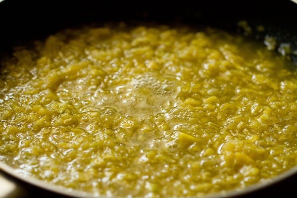 cooking the raw mango mixture in the pan. 