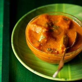 arachuvitta sambar in a bowl with a spoon kept on a green plate