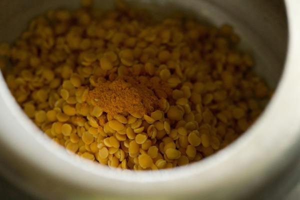 pressure cooking tuvar dal in water with turmeric powder