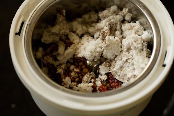 roasted spices with fresh grated coconut in a grinder jar