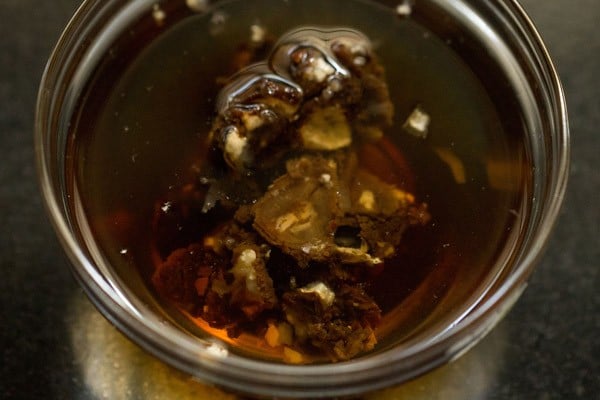 soaking tamarind in hot water in a bowl