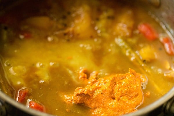 adding mashed dal and freshly ground sambar masala to vegetables in pan