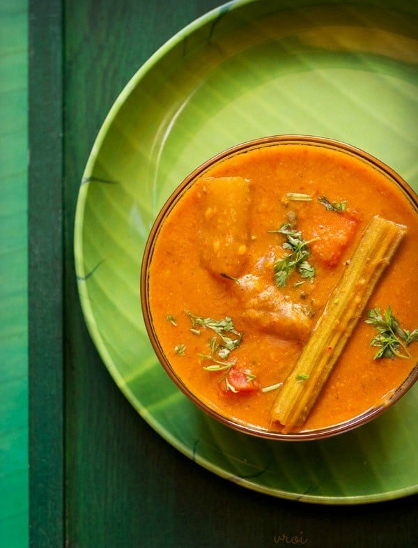 arachuvitta sambar garnished with coriander leaves and served in a bowl on a green plate