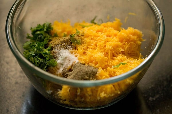 grated cheese, black pepper powder, cumin powder, chopped coriander leaves and salt added to mashed potatoes. 
