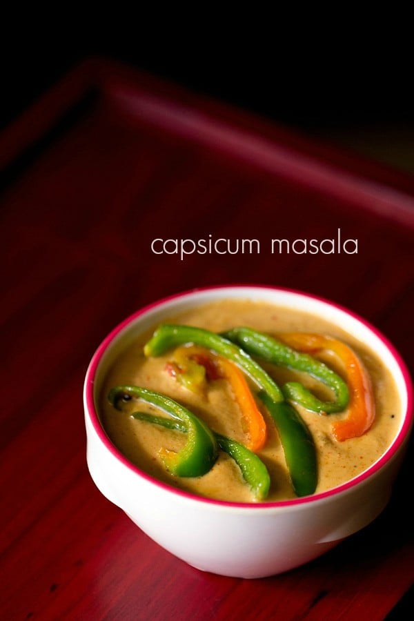 capsicum curry in a dark pink rimmed white bowl topped with colorful capsicum on a red board with text layovers