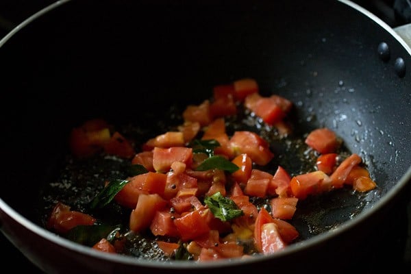 tomatoes, curry leaves and mustard seeds in pan