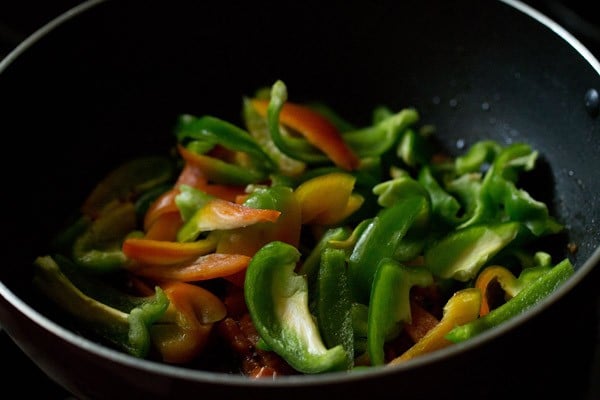 sliced capsicum and tomatoes in a pan