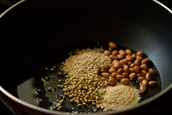 oil, peanuts, sesame seeds, coriander seeds and poppy seeds in a pan