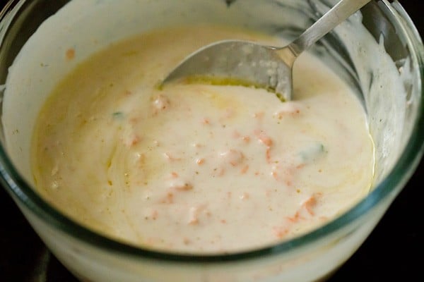 mixing carrot raita in the bowl