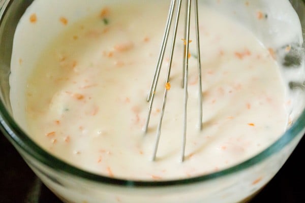 whisking the curd and herbs mixture in a bowl