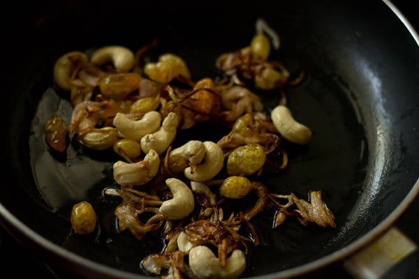 cashews, raisins, onions being sautéed
