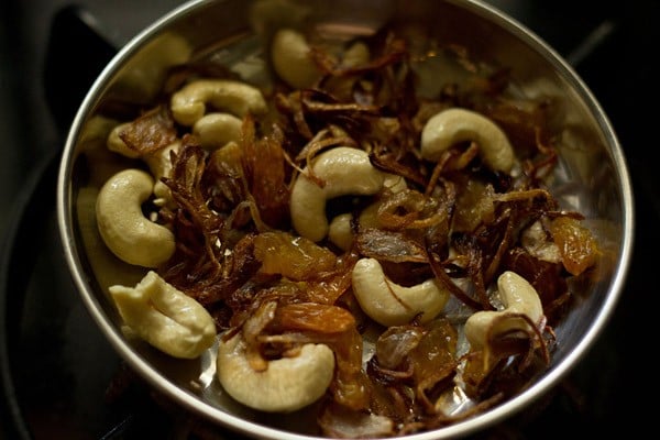 sautéed onions, raisins, cashew set aside in a small steel plate to make carrot rice recipe