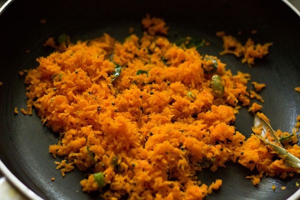 grated carrots being sautéed